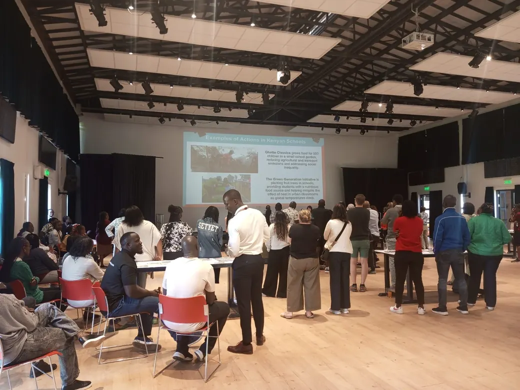 Delegates standing before a projected climate presentation during a Fresk session