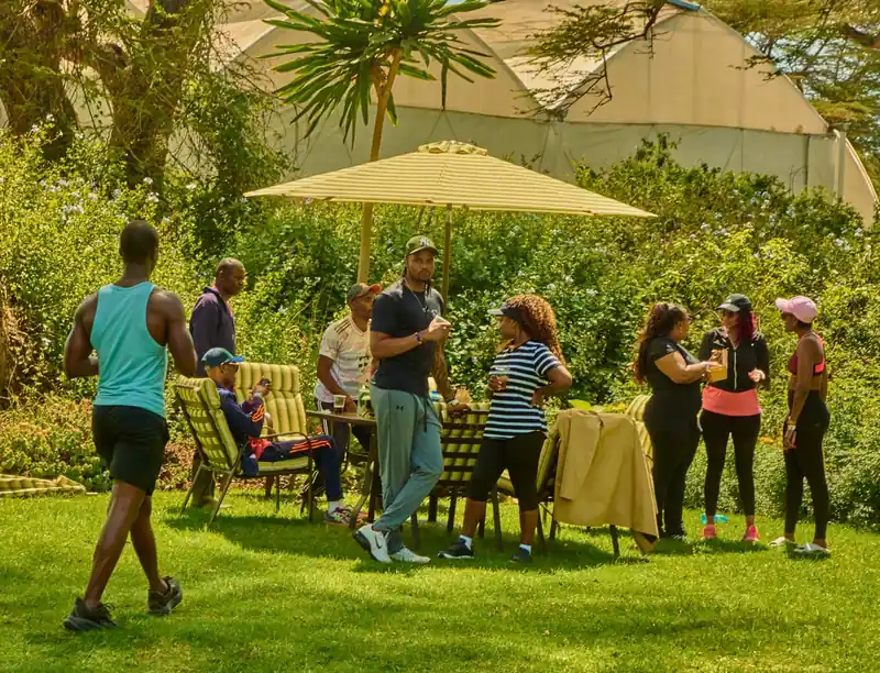 Participants relaxing on a lawn under a parasol during a wellness event in Naivasha