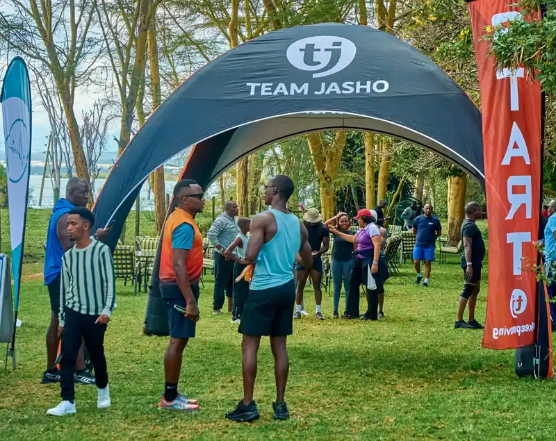 Participants gathered under the Team Jasho tent at a community event